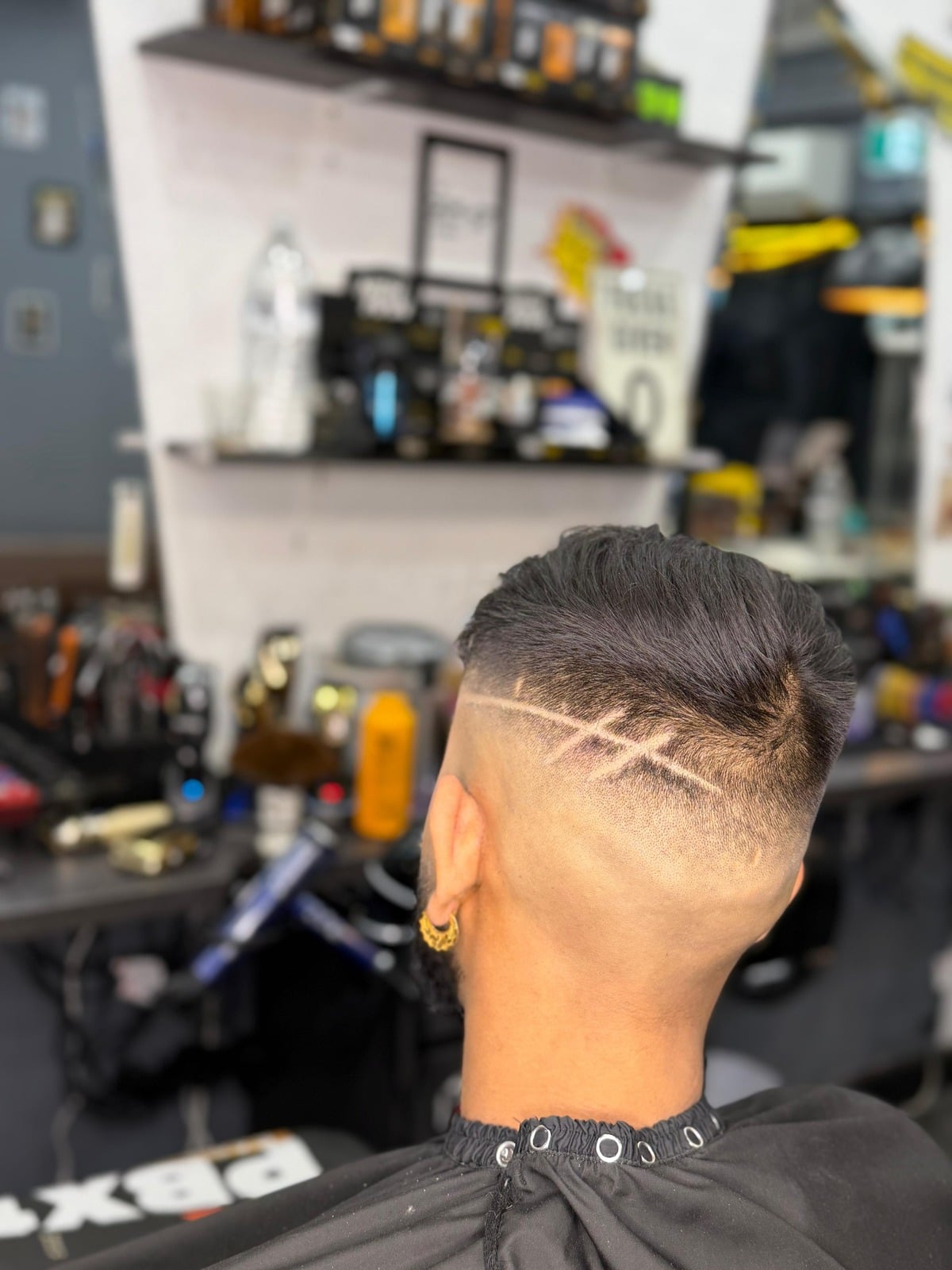Back of the head with a slick back fade and double hair tattoo lines