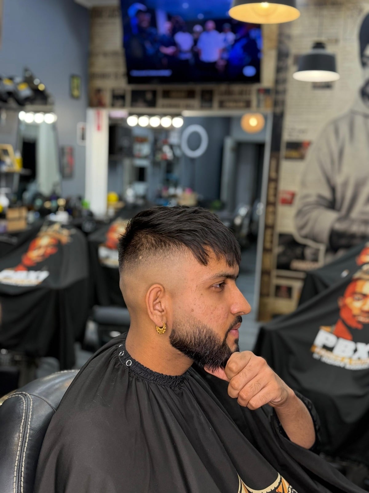 A PBX1 barber and client in the full Sydney shop during a cut